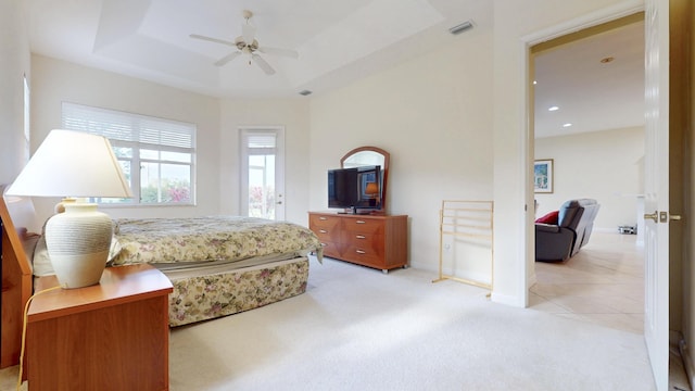 bedroom featuring light carpet, a raised ceiling, visible vents, and baseboards