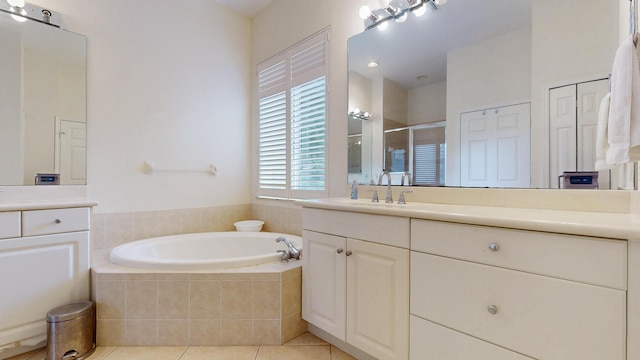 bathroom with a garden tub, a shower stall, vanity, and tile patterned floors