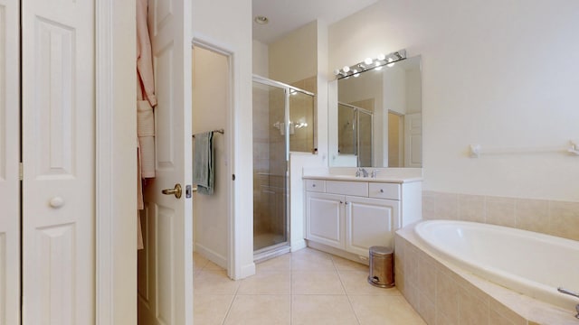 full bathroom featuring a garden tub, a closet, a shower stall, vanity, and tile patterned flooring