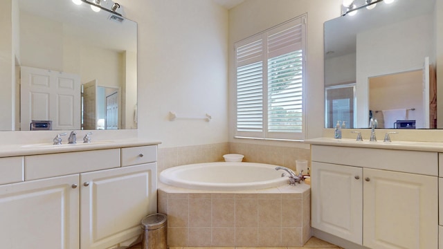 bathroom featuring two vanities, a sink, a shower stall, and a bath