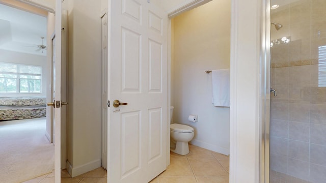 full bathroom with tile patterned flooring, toilet, a ceiling fan, baseboards, and a stall shower