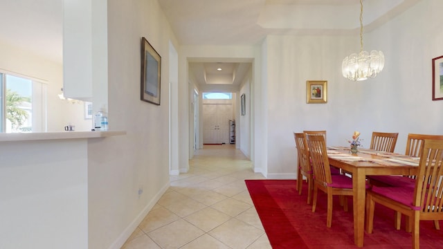 dining room featuring light tile patterned flooring, a notable chandelier, and baseboards