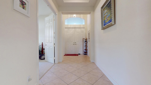 hall with light tile patterned flooring and baseboards