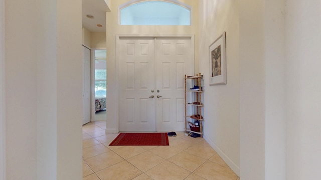 foyer entrance featuring baseboards and light tile patterned flooring