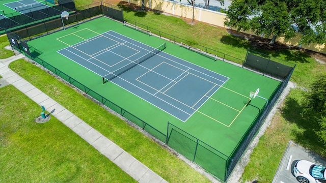 view of tennis court with a yard, fence, and community basketball court