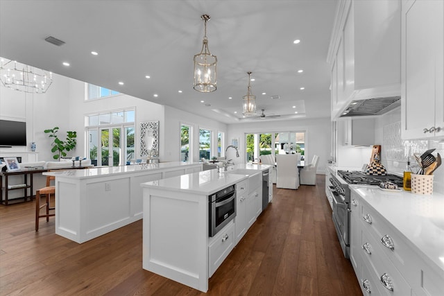 kitchen with stainless steel appliances, dark wood-type flooring, a spacious island, visible vents, and open floor plan