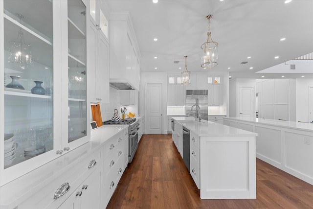 kitchen with a large island, high quality appliances, and white cabinets