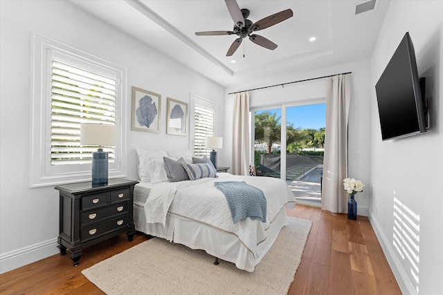 bedroom with access to exterior, a raised ceiling, visible vents, and baseboards