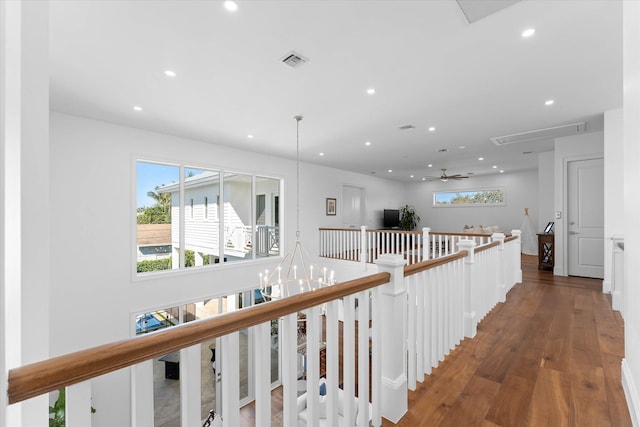 hallway featuring visible vents, wood finished floors, an upstairs landing, and recessed lighting