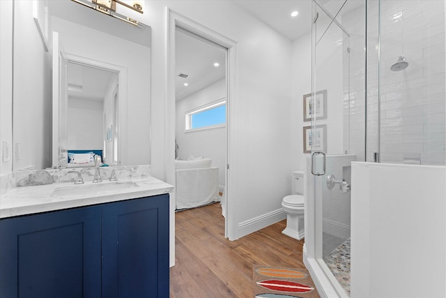 full bath with visible vents, toilet, a stall shower, vanity, and wood finished floors