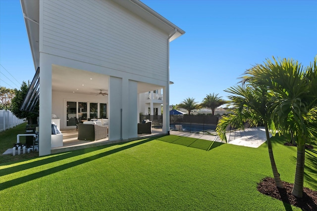 view of yard featuring a patio, outdoor lounge area, a fenced backyard, and a ceiling fan