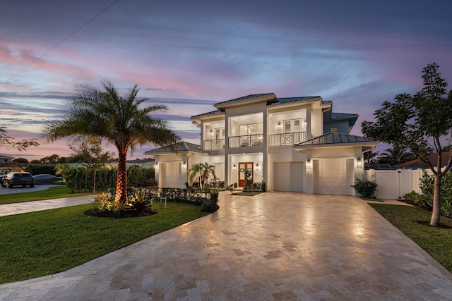 mediterranean / spanish-style home with decorative driveway, a standing seam roof, metal roof, and a balcony