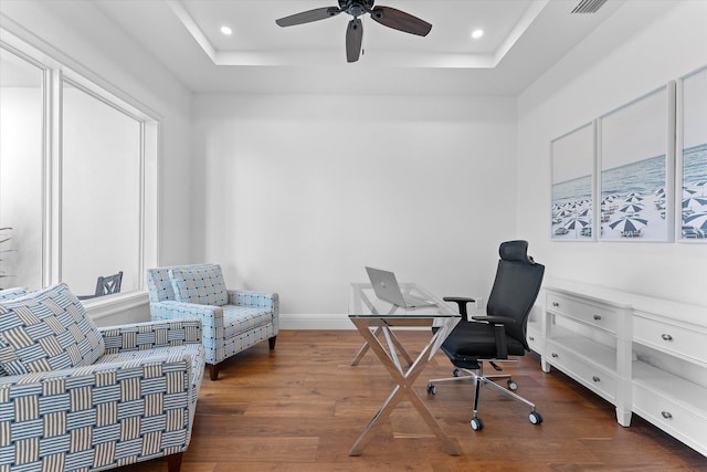 office featuring a tray ceiling, hardwood / wood-style floors, and recessed lighting