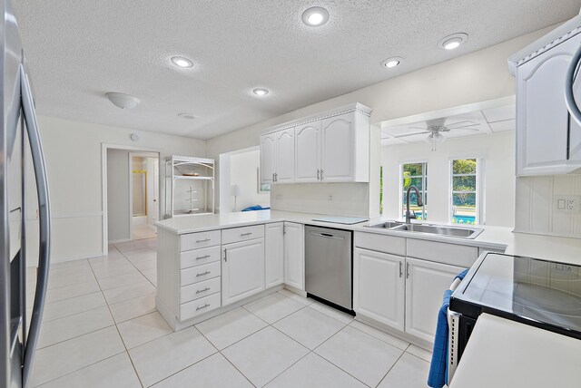 kitchen with a sink, a peninsula, light countertops, and stainless steel appliances