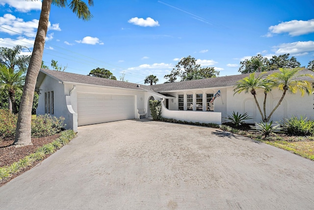 ranch-style house with stucco siding, an attached garage, and concrete driveway