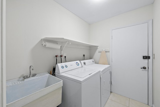 laundry area featuring a sink, light tile patterned flooring, laundry area, and washing machine and clothes dryer