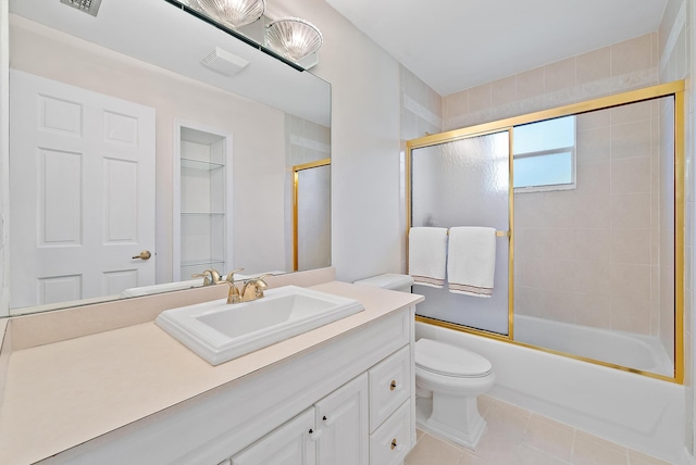 bathroom with vanity, visible vents, tile patterned flooring, toilet, and combined bath / shower with glass door