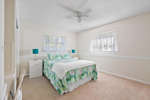 carpeted bedroom featuring baseboards, a textured ceiling, and ceiling fan