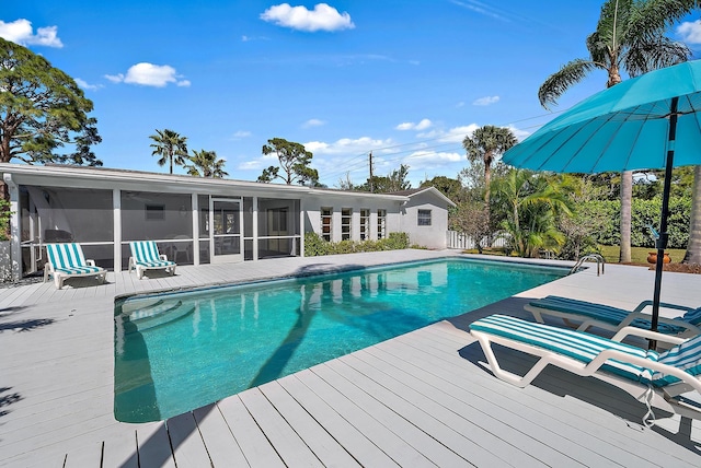 pool with a wooden deck and a sunroom