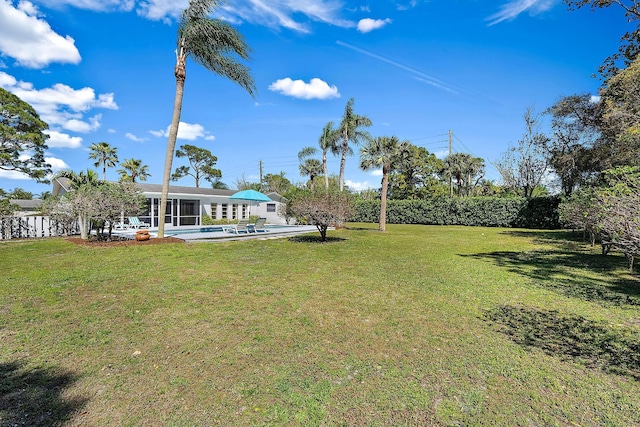 view of yard featuring an outdoor pool and a sunroom