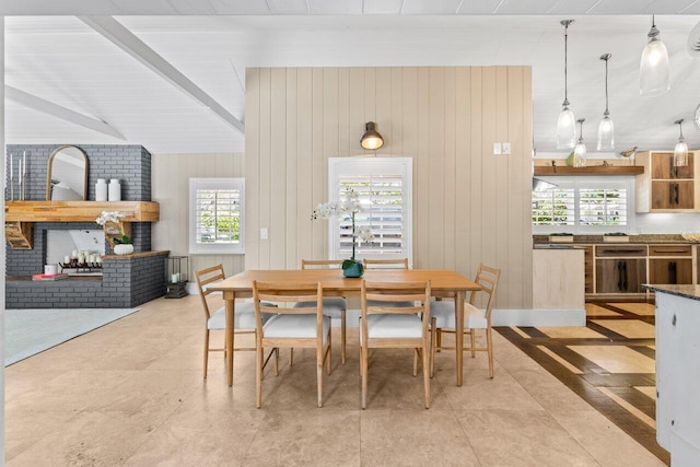 dining space with wooden walls and lofted ceiling with beams