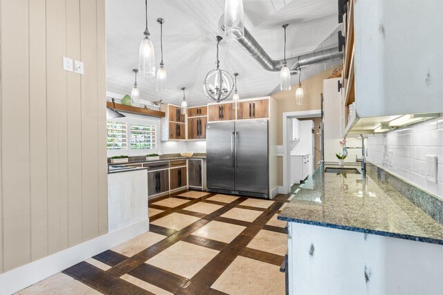 kitchen with lofted ceiling, a sink, appliances with stainless steel finishes, decorative backsplash, and open shelves