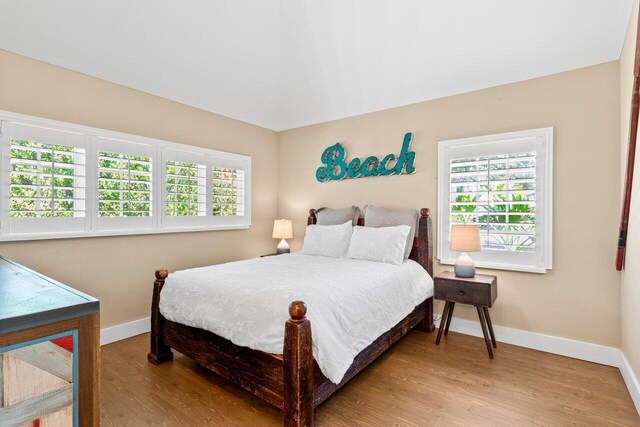 bedroom with baseboards and wood finished floors