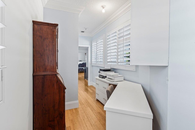 office space featuring baseboards, light wood-style flooring, ornamental molding, and a textured ceiling