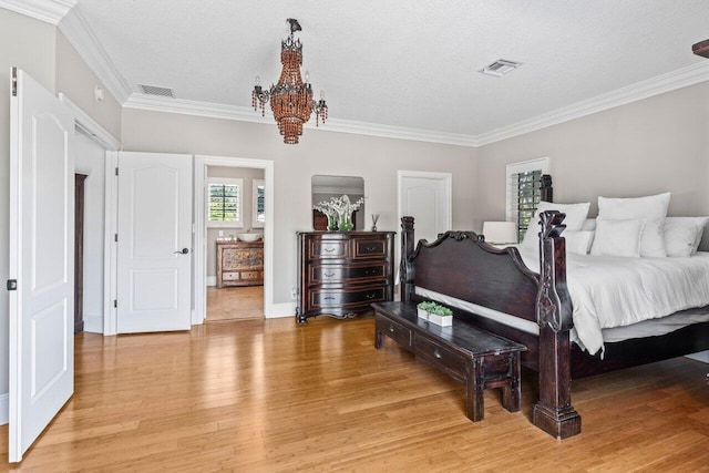 bedroom with ornamental molding, light wood-type flooring, visible vents, and an inviting chandelier