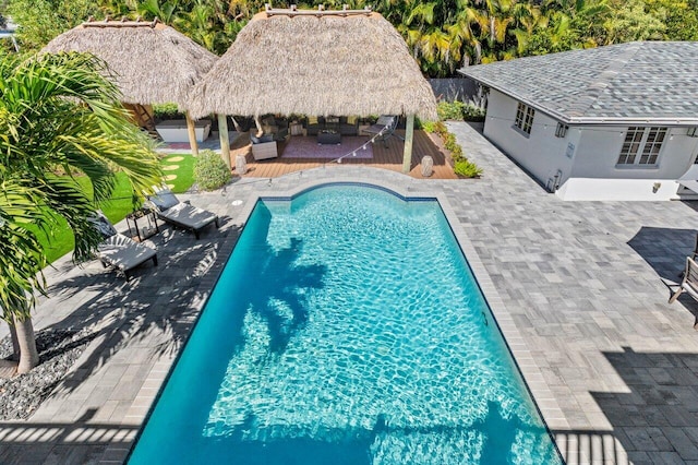 outdoor pool with a gazebo, a fenced backyard, outdoor lounge area, and a wooden deck