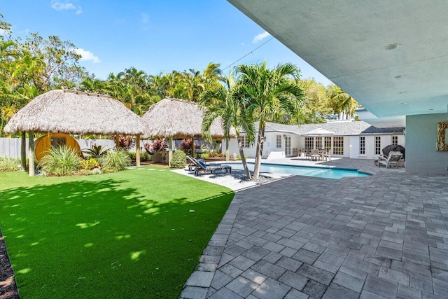 view of pool featuring a gazebo, french doors, a lawn, a fenced in pool, and a patio area