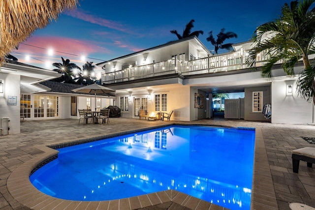 outdoor pool featuring a patio and french doors