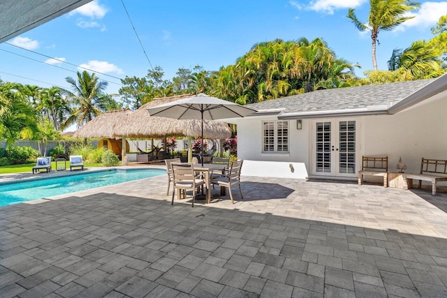 view of swimming pool with a fenced in pool, fence, outdoor dining area, french doors, and a patio area