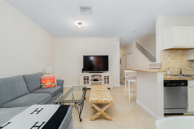 living area featuring light tile patterned floors, baseboards, stairway, and visible vents