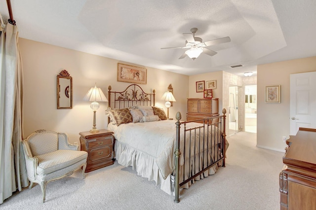 bedroom with light carpet, a ceiling fan, and connected bathroom
