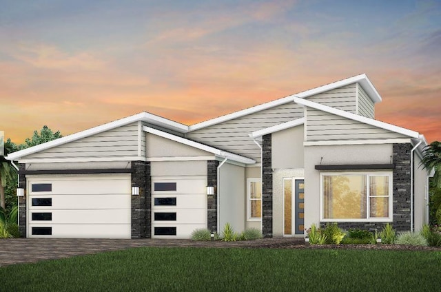 view of front of house with an attached garage, stone siding, driveway, and a front lawn