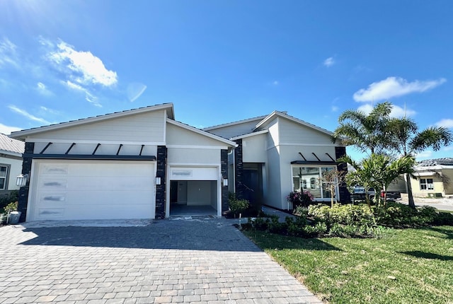 view of front of house featuring a garage, a front yard, and stucco siding