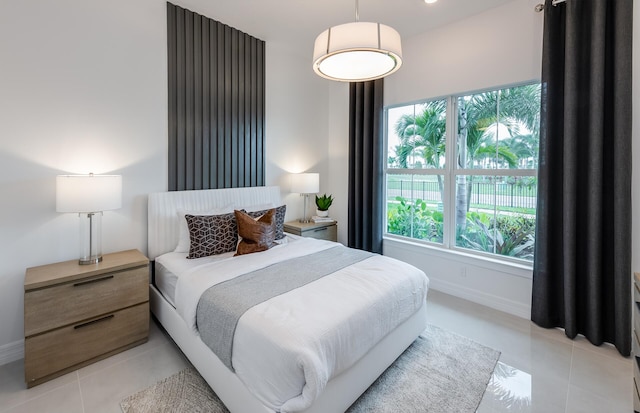 bedroom with light tile patterned flooring and baseboards