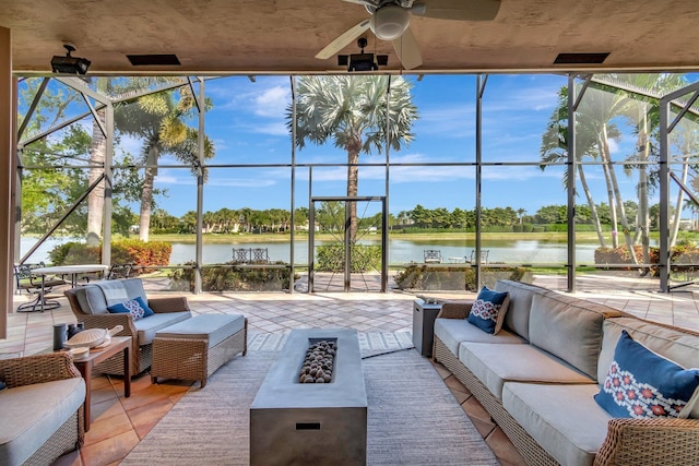 sunroom / solarium with ceiling fan, a water view, and a healthy amount of sunlight