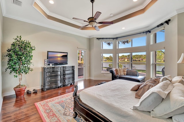 bedroom with crown molding, a raised ceiling, visible vents, and access to exterior