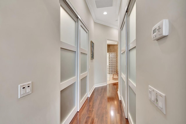 hall with recessed lighting, dark wood-type flooring, visible vents, baseboards, and ornamental molding