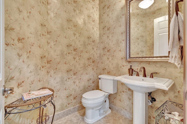 bathroom with baseboards, wallpapered walls, toilet, and tile patterned floors