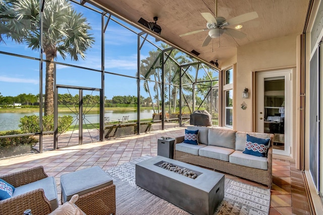 sunroom / solarium with a water view and ceiling fan