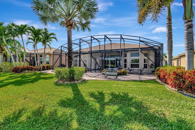 back of property with a lanai, a patio, and a lawn