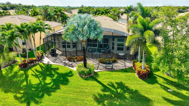 back of house with a lanai, a patio area, a tile roof, and a yard