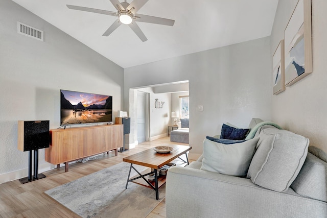 living room featuring a ceiling fan, light wood-style flooring, visible vents, and baseboards