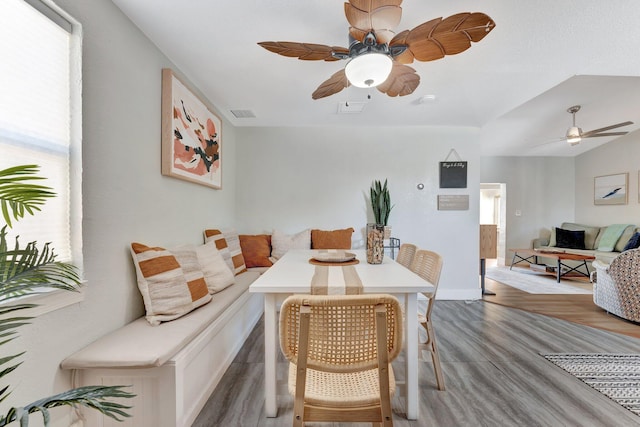 dining space with wood finished floors, visible vents, and a ceiling fan