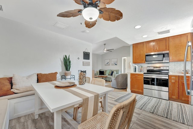 dining room with visible vents, vaulted ceiling, and a ceiling fan