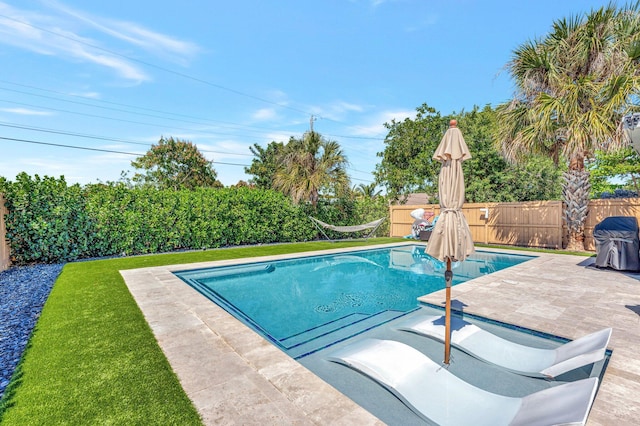 view of pool with a fenced in pool, a patio area, a fenced backyard, and a yard