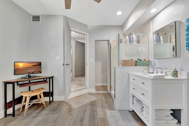 bathroom with visible vents, a shower stall, vanity, wood finished floors, and baseboards